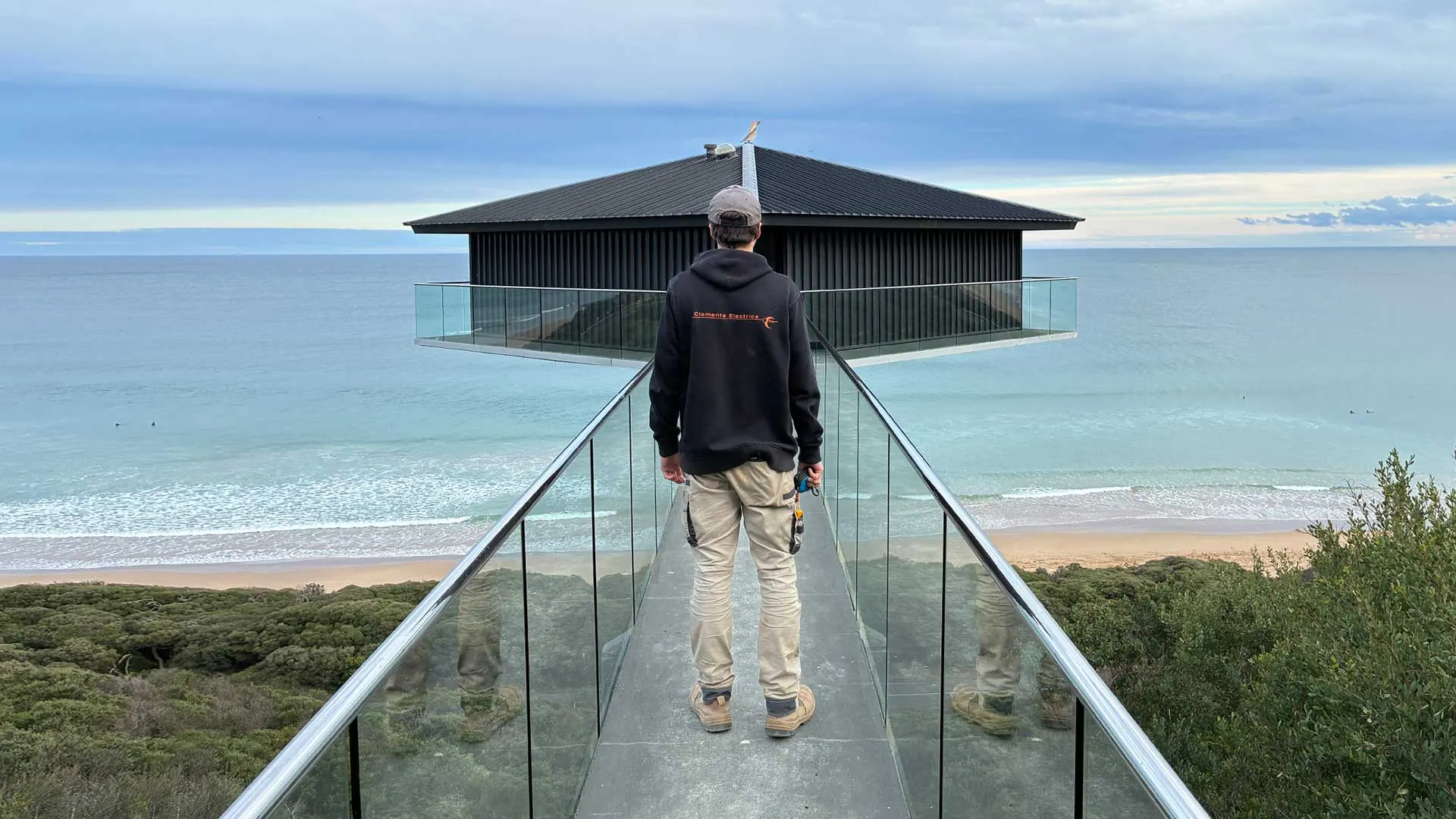 Clements Electrics electrician standing in front of the iconic Pole House in Fairhaven on the Great Ocean Road