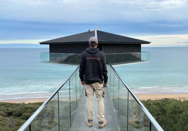 Clements Electrics electrician standing in front of the iconic Pole House in Fairhaven on the Great Ocean Road